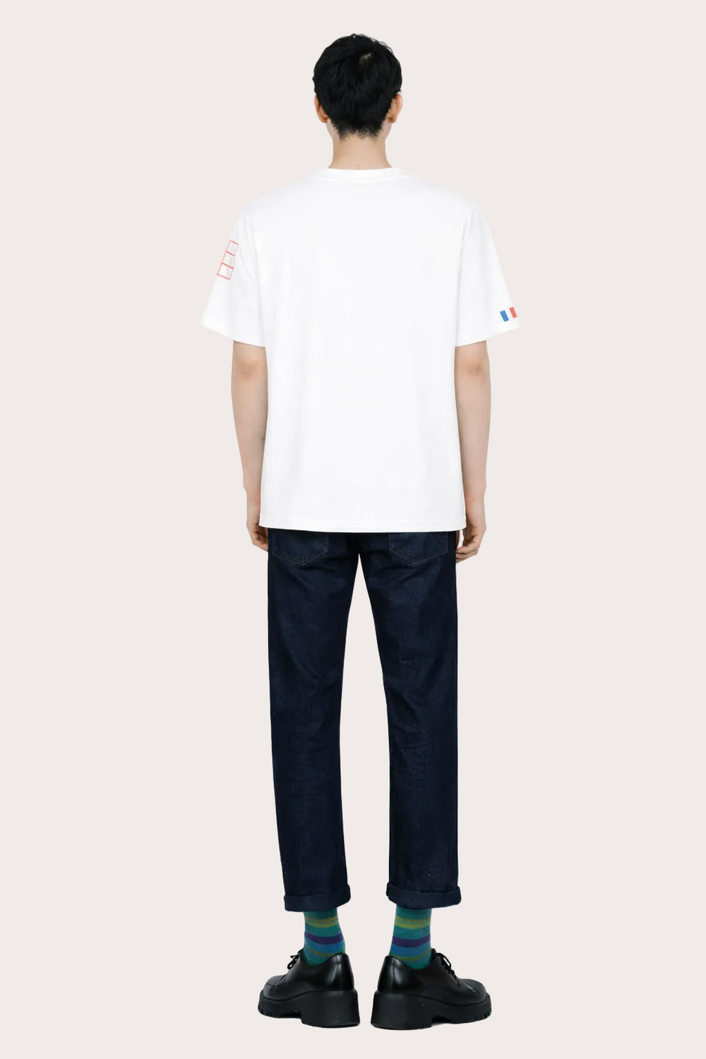  Image de dos du T-shirt Vague blanc unisexe en coton biologique certifié GOTS, coupe droite avec détail tricolore signature sur la manche gauche.