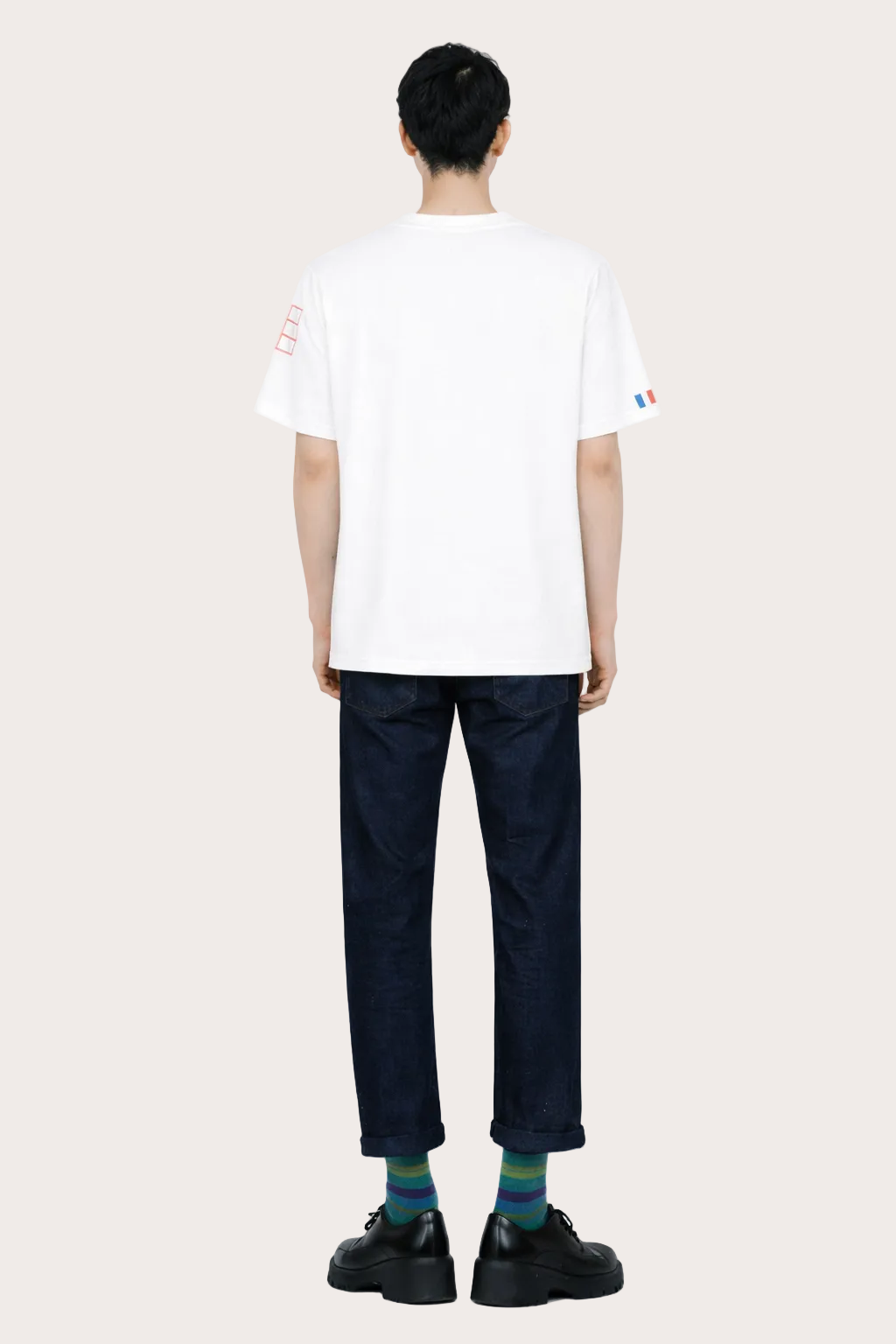  Image de dos du T-shirt Vague blanc unisexe en coton biologique certifié GOTS, coupe droite avec détail tricolore signature sur la manche gauche.